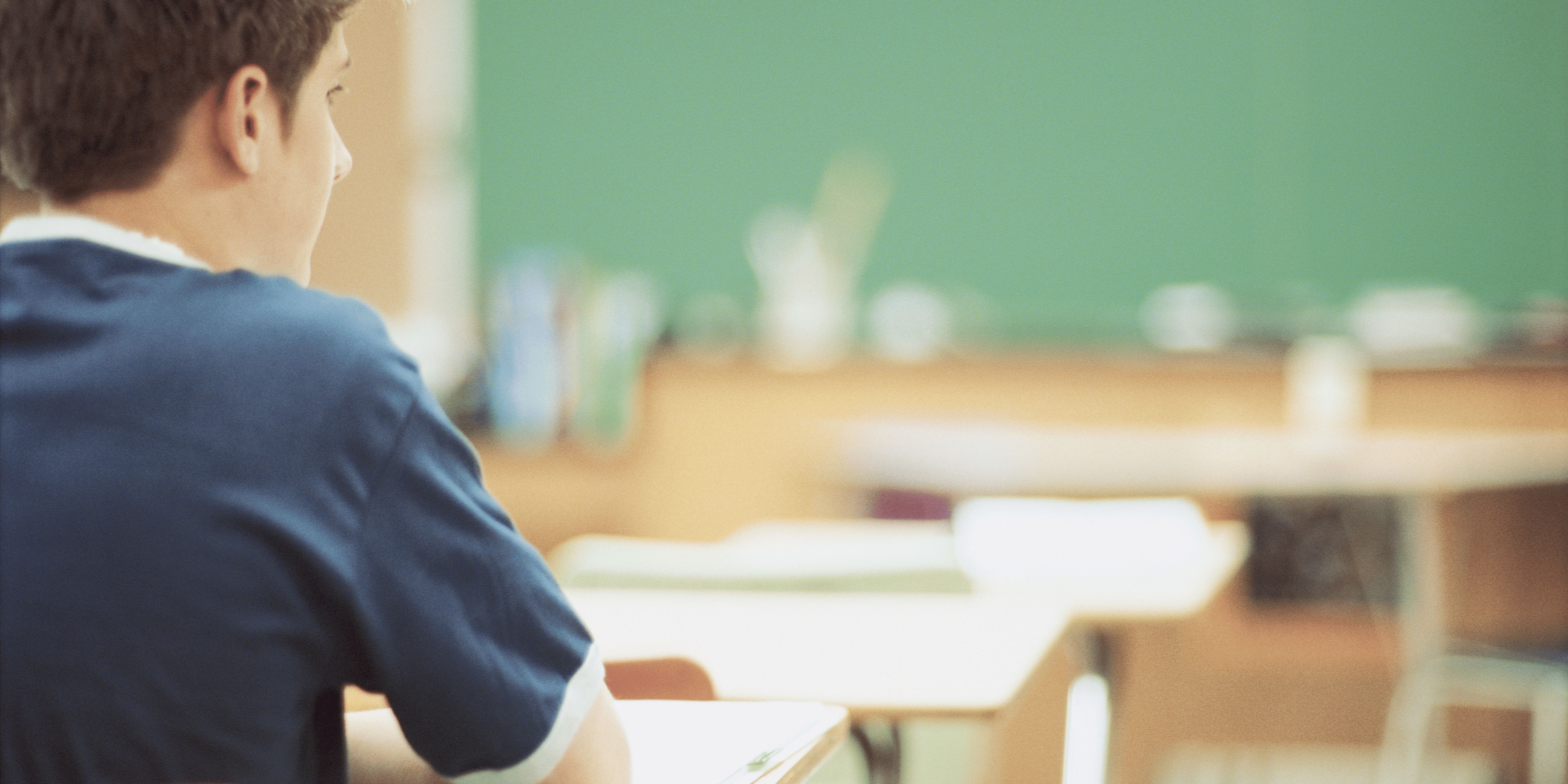 teen boy sitting in a classroom